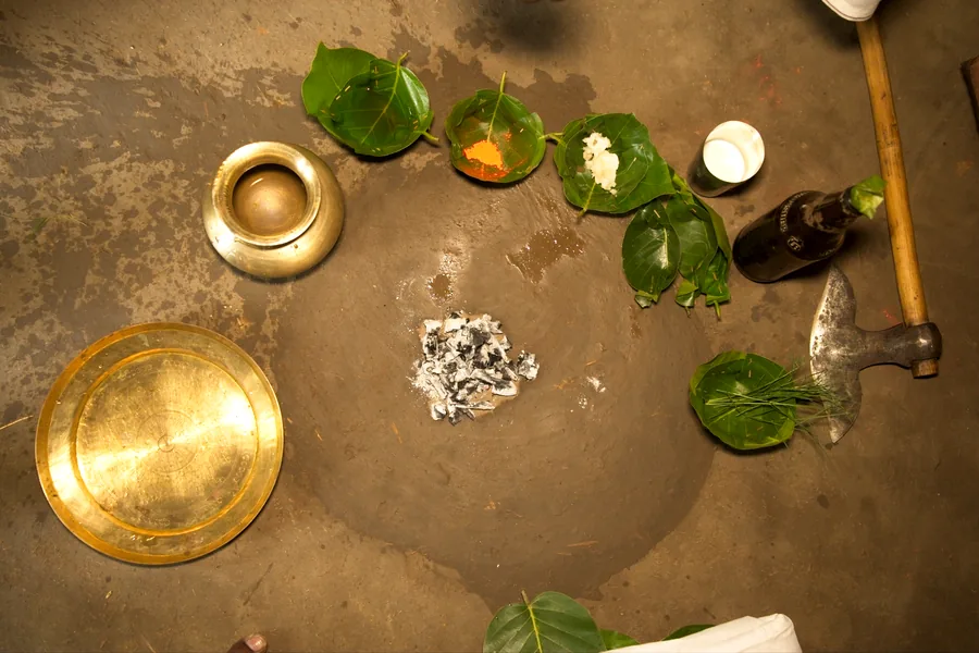 Surreal Surguja Culture: brass vessels and betel leaves arranged on an earthen floor.